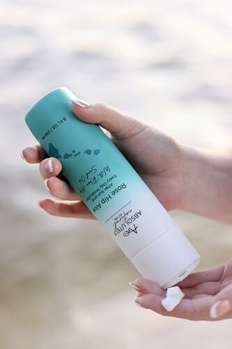 Hands holding skincare product with lotion